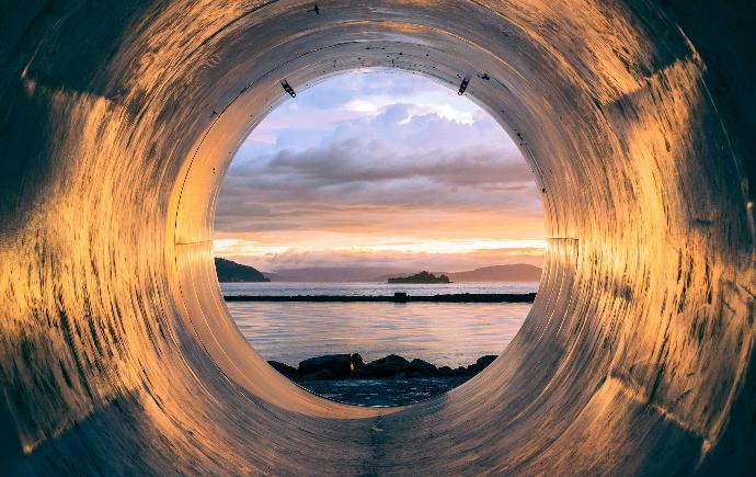 body of water can be seen through the tunnel